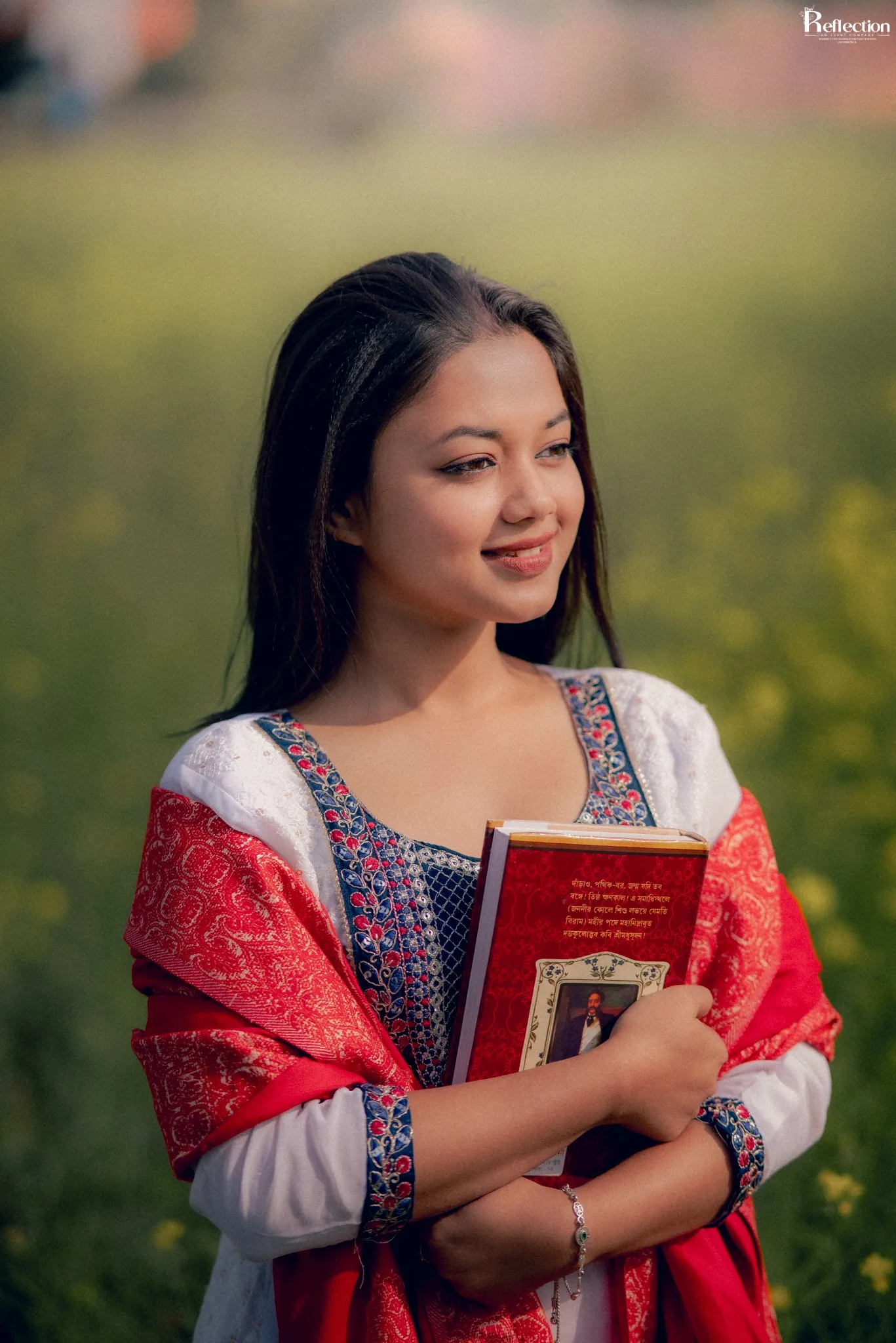 Outdoor lifestyle portrait of a woman holding a book